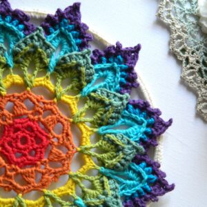 Attrape-rêves BIFROST au crochet - gros plan droit Attrape-rêves mandala multicolore représentant les couleurs des chakras, entièrement réalisé au crochet.
