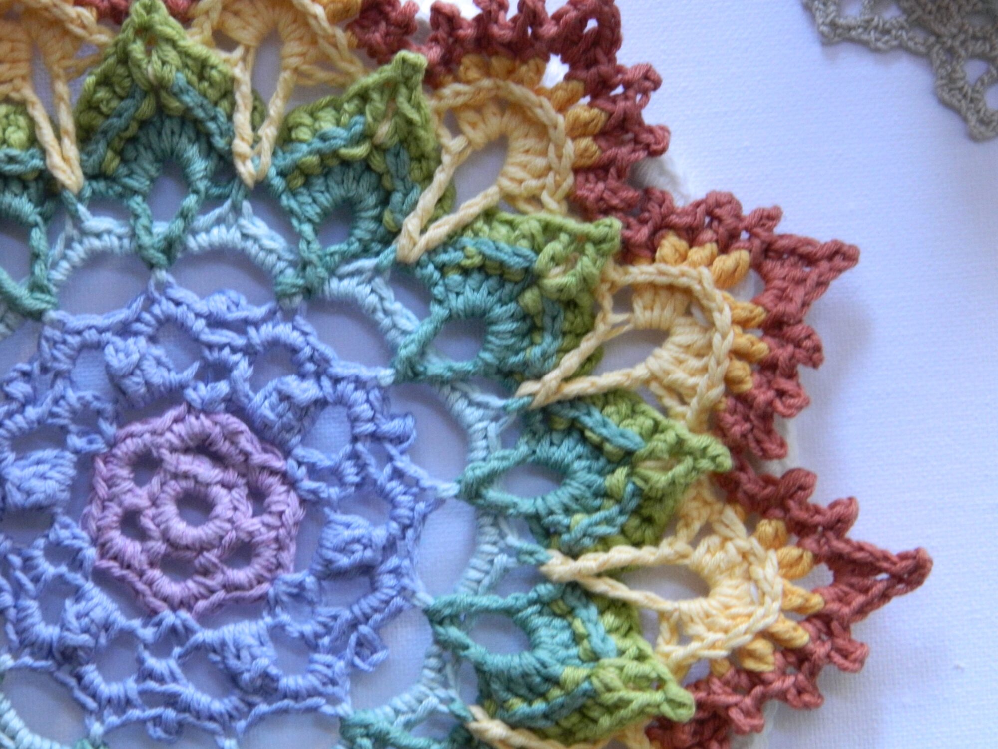 Attrape-rêves mandala multicolore représentant les couleurs des chakras, entièrement réalisé au crochet.