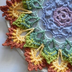 Attrape-rêves mandala multicolore représentant les couleurs des chakras, entièrement réalisé au crochet.