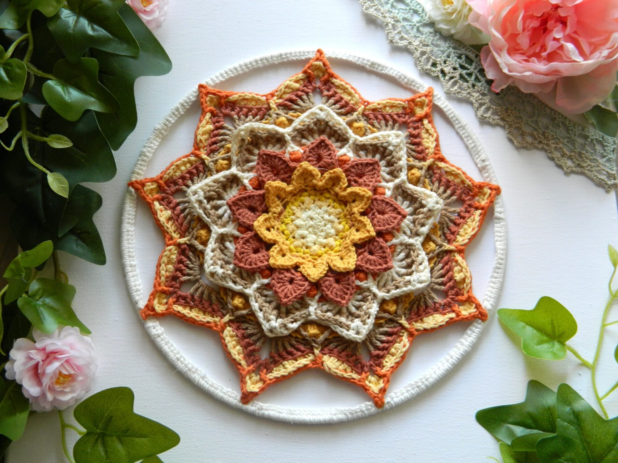 Attrape-rêves mandala au crochet dans des tons terracotta, beige et écru, réalisé entièrement à la main pour une décoration bohème et spirituelle.