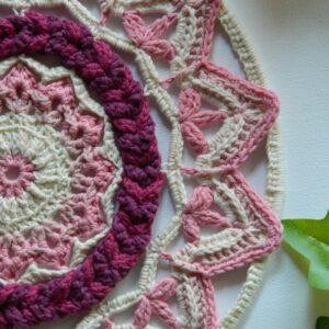 Attrape-rêves mandala au crochet dans des tons roses et blancs réalisé entièrement à la main.