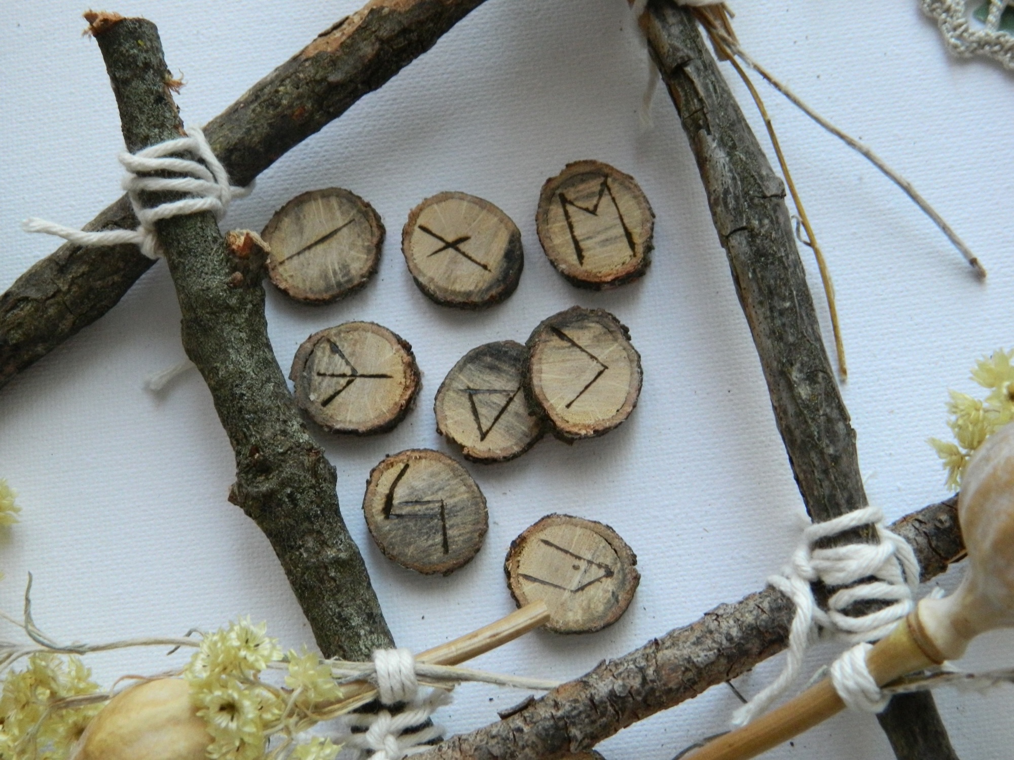 Runes en chêne – artisanat spirituel Runes en chêne gravées à la main disposées dans une composition naturelle évoquant les traditions nordiques et la pratique divinatoire.