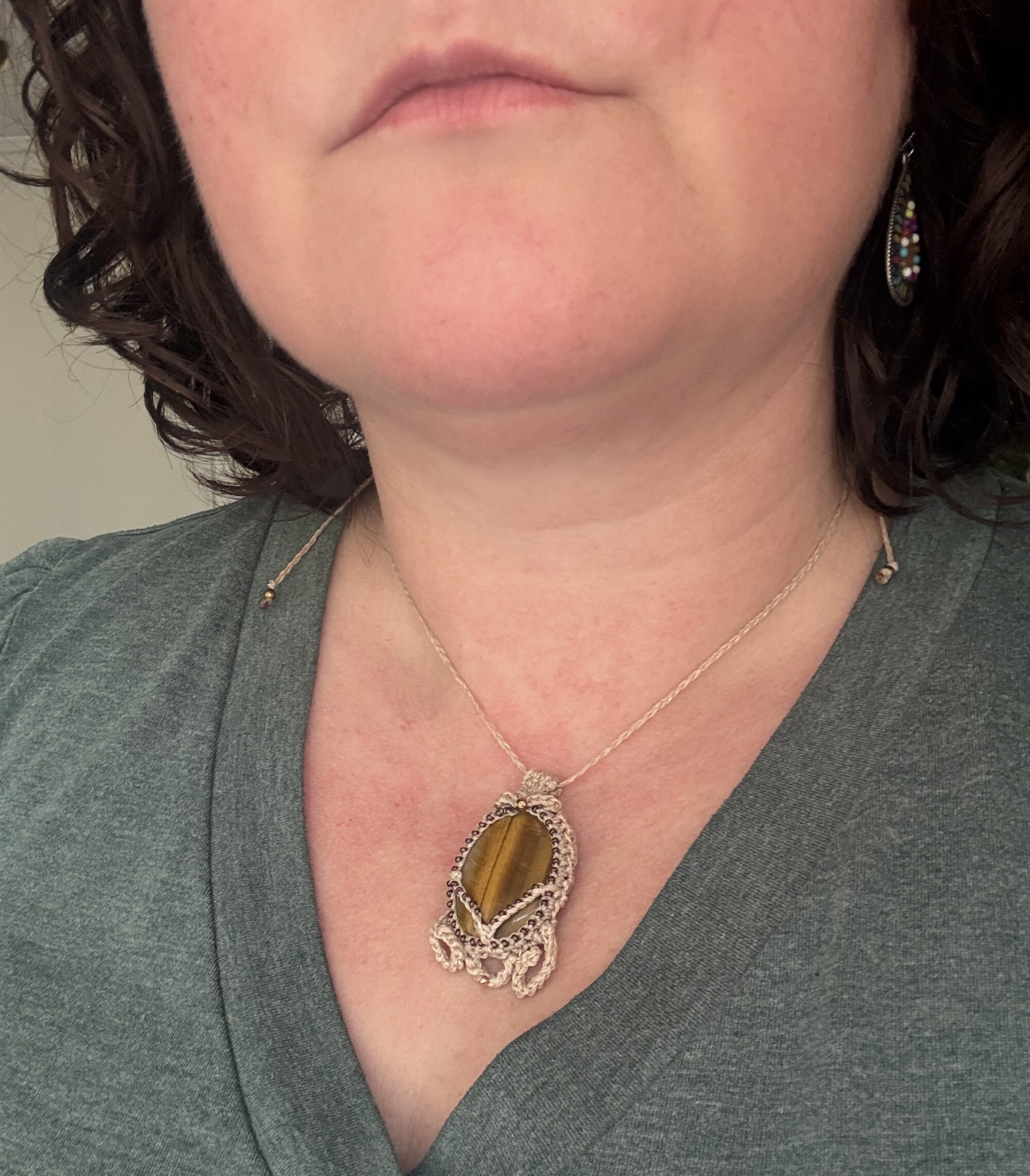 Collier BRUNN SKJOLDR en œil de tigre et au micro crochet beige porté autour du cou